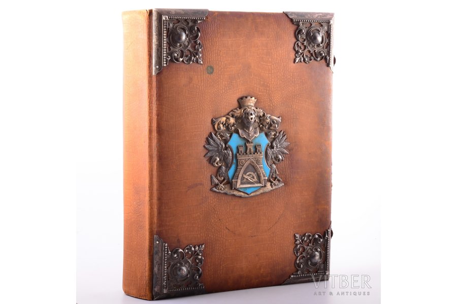 The Photo Album was a gift to the senior foreman of the Guild of Bricklayers of Riga City Vilhelm Donberg on March 13, 1902. It was presented for 50th Anniversary of his tenure as a Head of the Guild. The cover page of the album has an image of the coat of arms of the Riga Guild of Bricklayers. The first sheet with a photo has a floral frame with depicted the coat of arms and views of Riga, which was hand painted with watercolors. Vilhelm Donberg in his work's costume is depicted in the stained glass of the Small Guild building, 1902, Riga, 41 х 34.5 х 10.5 cm, silver cover plates: 84 hallmark, Riga silversmith EB (hallmark N3299a, page 240, М.М.Постникова-Лосева, «Золотое и серебряное дело XV-XXв», М.1995)