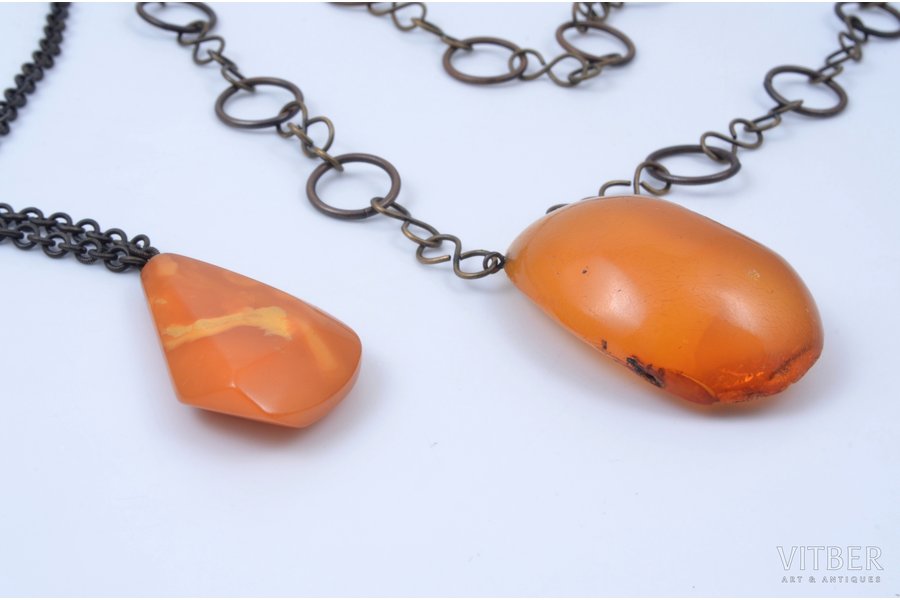 two pendants, amber, 6.3 + 17.9 g., the item's dimensions 4.3x2.8x1.05 / 5.1x3.9x1.8 cm, weight and dimensions indicated without chains